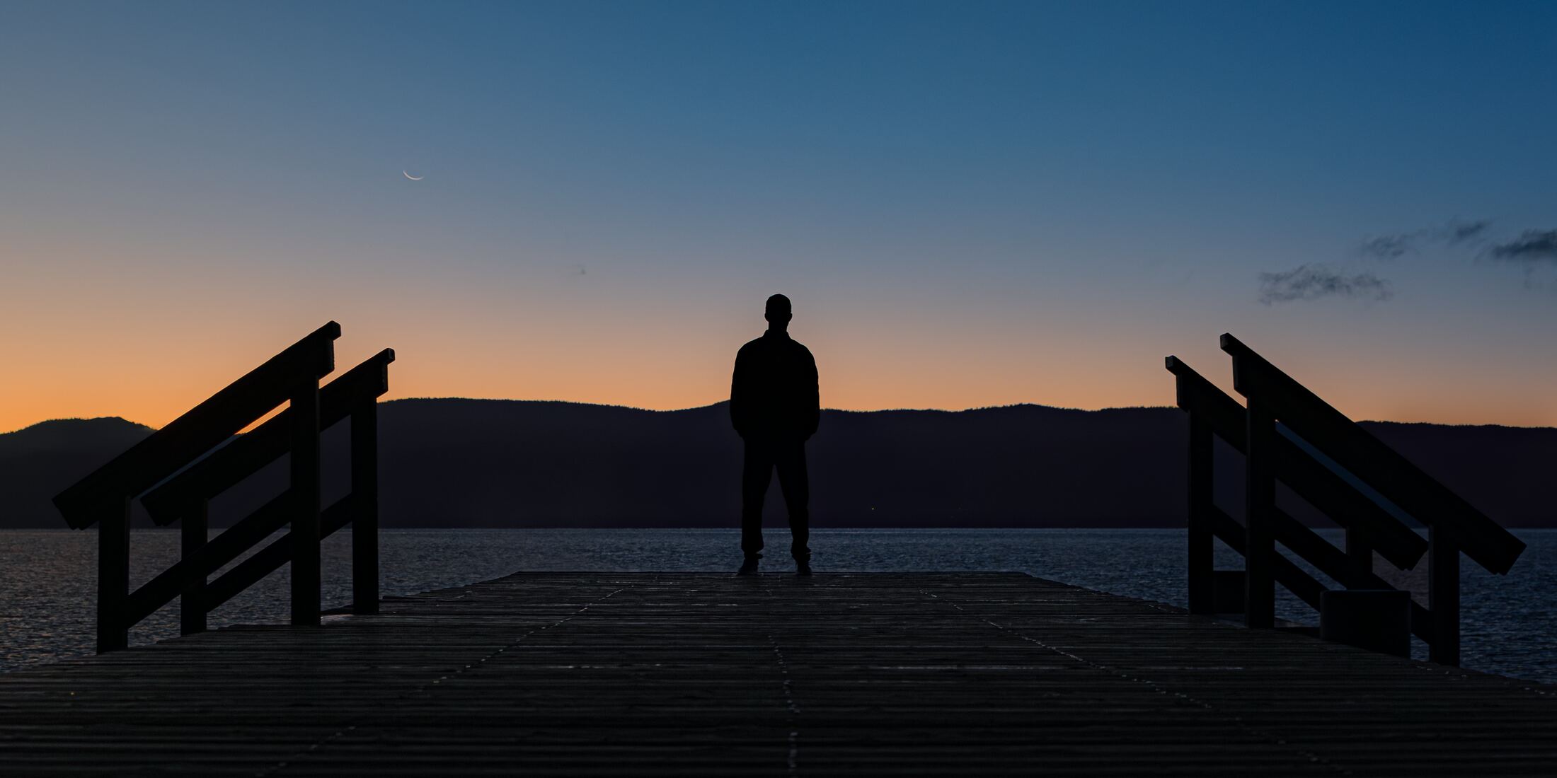 MKE standing at the end of a pier on Lake Tahoe at dusk